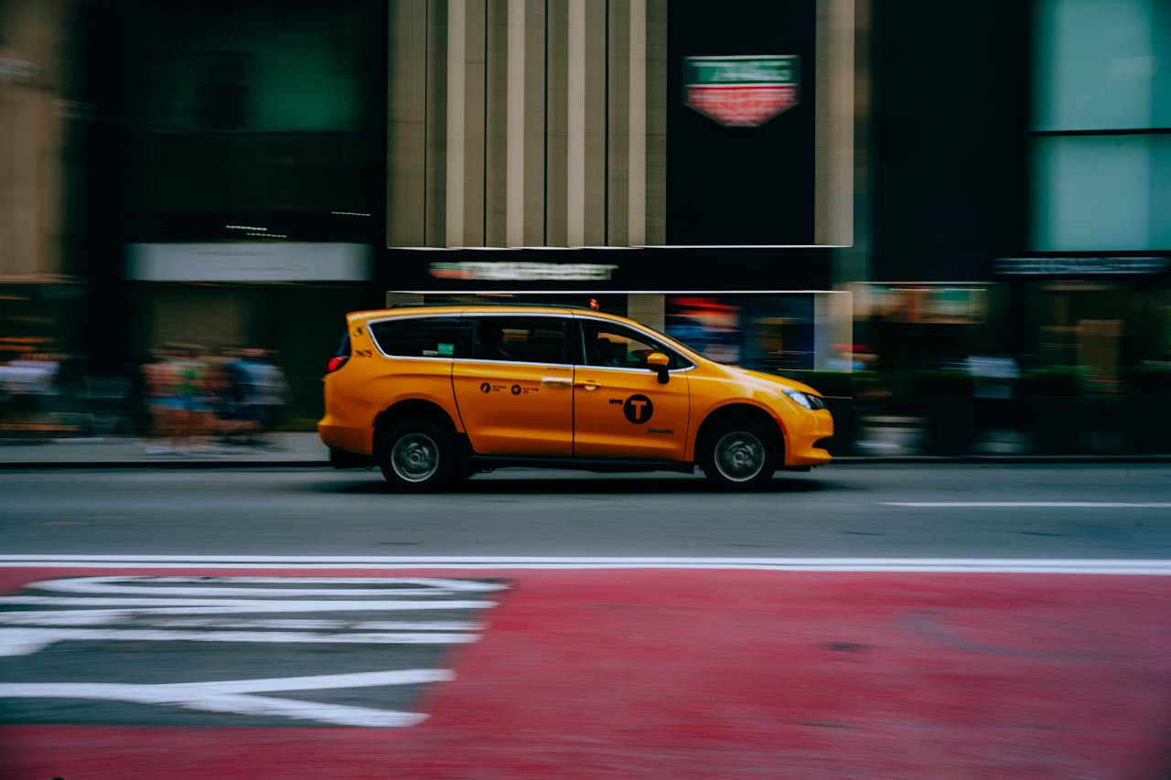 Dynamic shot of a yellow taxi speeding through a New York City street.